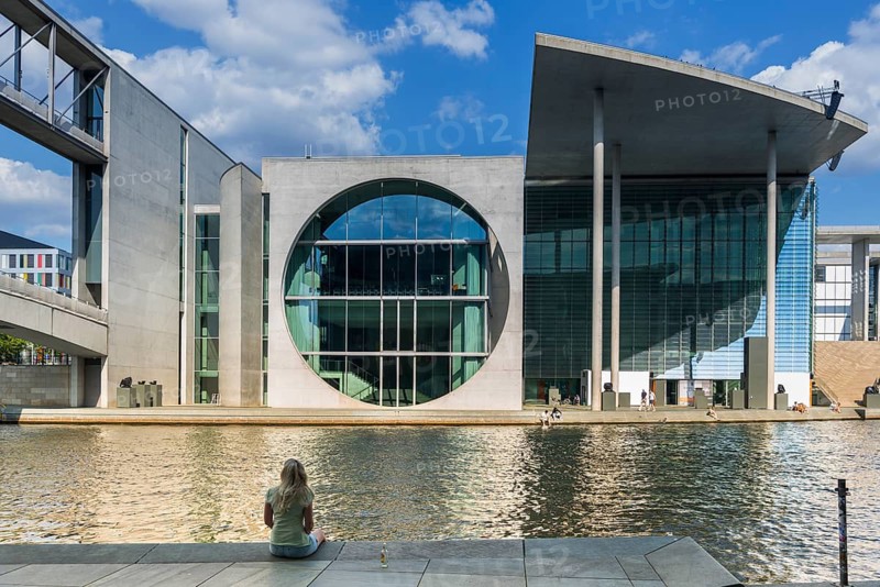 Woman sitting in the sun on the banks of the Spree at Marie-Elisabeth-Lüders-Haus in the government district, Berlin