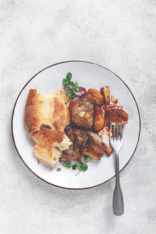 A plate with leftover pork kebab, with bread, on a white plate, close-up, there are no people