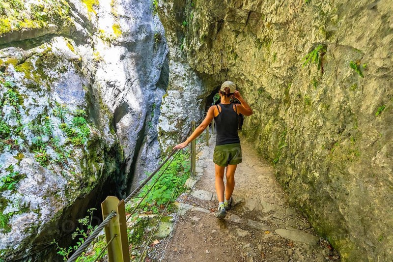Female tourist exploring the scenic tolmin gorges in slovenia, enjoying the natural beauty of the canyon on a summer day