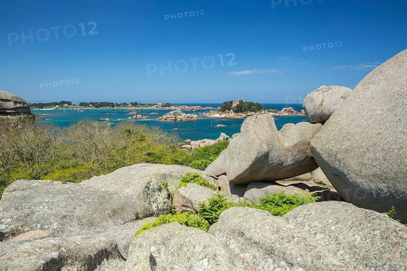 Beach with rocks and sand at the Plage Saint Guirec, with clear blue sky and colors as in the carribians