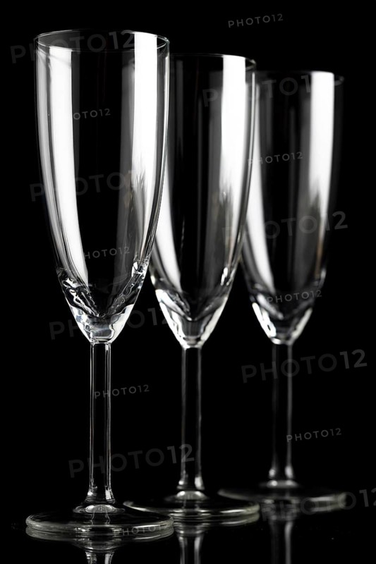 Three empty champagne glasses against a black background