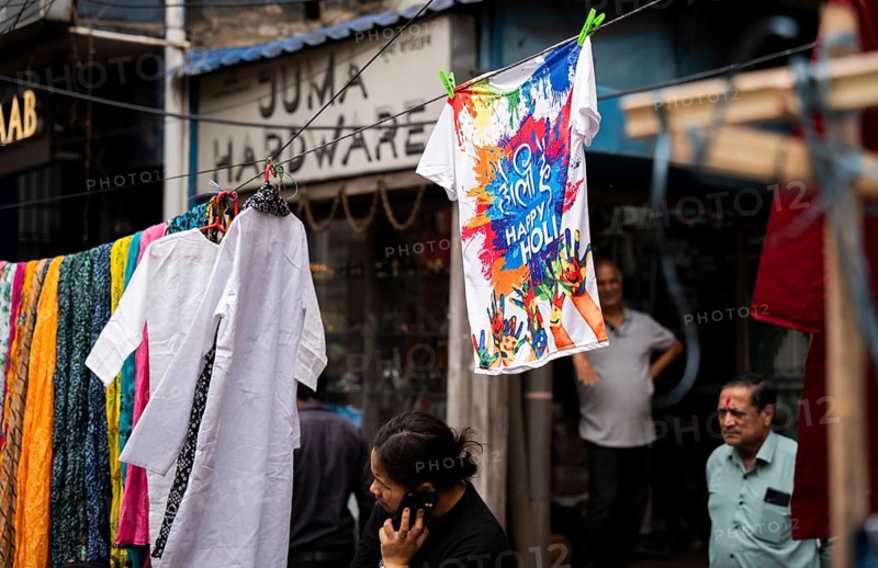 Vendor sells Happy Holi t-shirt in a market on the eve of Holi Festival, on March 13, 2025 in Guwahati, India. Holi is a Hindu festival celebrated mainly in India marking the arrival of spring it is also known as the Festival of colors, as people throw vibrant colored powders at each other, dance, and celebrate with music and sweets