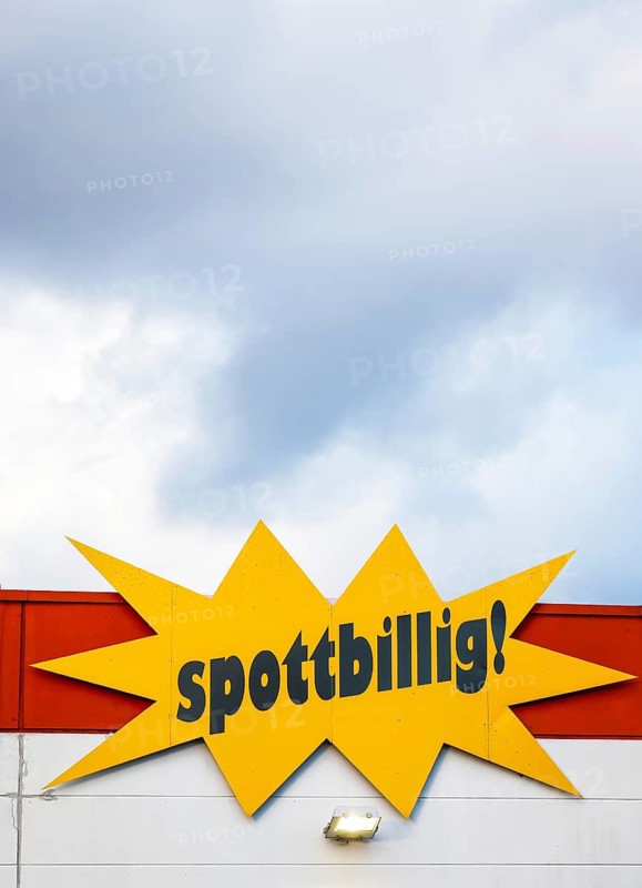 Mülheim, North Rhine-Westphalia, Germany - mock-cheap, lettering on the facade of a speciality store in front of a cloudy sky