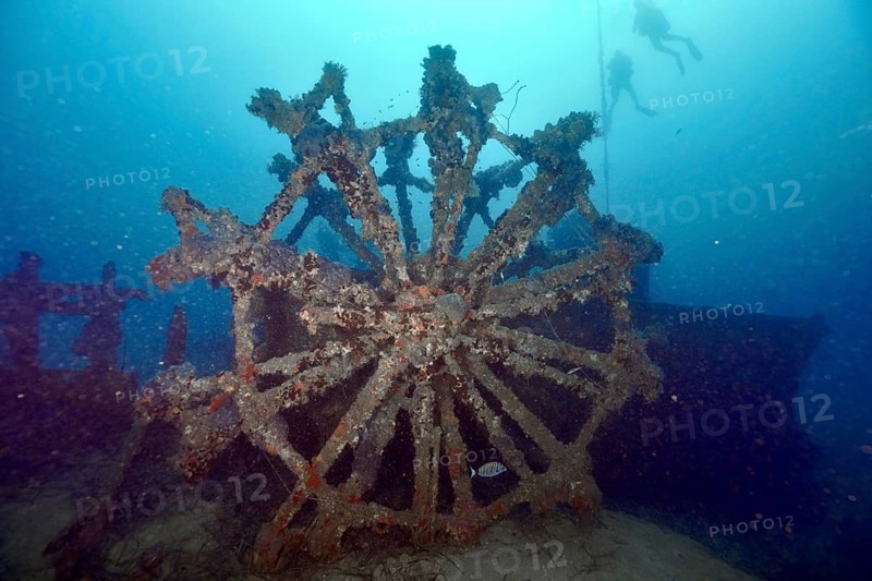 Divers approach a large dilapidated paddle wheel of a shipwreck, dive site Wreck Ville de Grasse, Hyères, Giens Peninsula, Mediterranean Sea, Porquerolles, Provence, Côte d'Azur, France