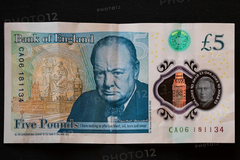 Close-up of a Bank of England five pound note featuring Sir Winston Churchill and the portrait of King Charles III