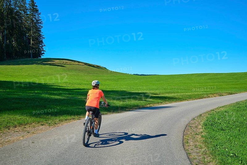 Active senior woman rides her electric mountain bike in Westallgäu near Lindenberg, Bavaria, Germany