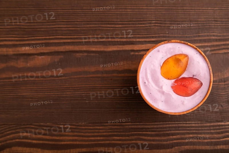 Purple Yogurt, with jelly candy on brown wooden background, top view, flat lay, copy space, minimalism