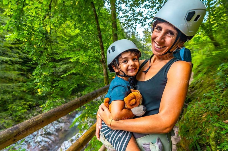 Mother holding her child while enjoying a scenic walk through the beautiful vintgar gorge near bled, slovenia