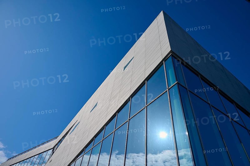 Modern building More og Romsdal Art Centre with glass front and reflecting blue sky, Molde, Romsdal, Norway