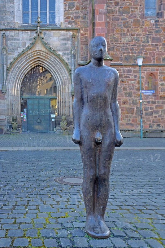 Sculpture Out of the dark by Antony Gormley 1987, dark black naked male figure, darkness, dark, smooth bronze sculpture, standing, St Martin's Church, Kassel, Hesse, Germany