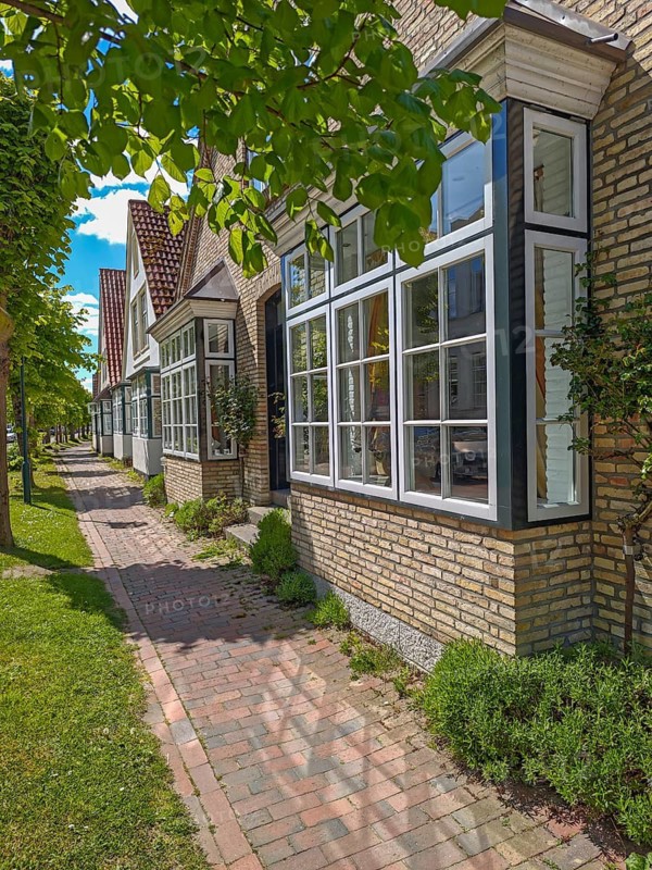 Historic row of houses with bay windows in Lange Strasse, gabled houses, footpath, trees, Arnis, building material yellow brick, smallest town in Germany, Schlei region, landscape Angeln, Schleswig-Holstein, Germany