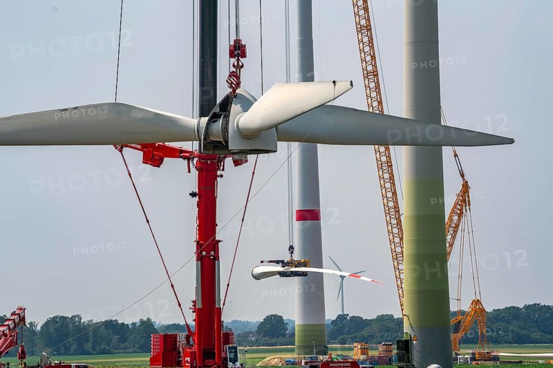 Dismantling of a wind power plant in a wind farm near Issum, 9 older wind turbines from the manufacturer Enercon (model series E-58), front, blades being dismantled, were in operation for over two decades, will be replaced by a total of four Enercon E-160 turbines, rear, assembly of the first blade, with a total output of 22 megawatts, Lower Rhine, North Rhine-Westphalia, Germany