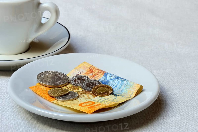 Tip, Swiss coins and Swiss franc note on plate, Switzerland