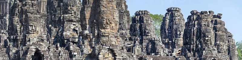 Panoramic image of giant stone-carved faces of the Bodhisattva Lokeshvara, also known as Avalokiteshvara, Bayon Temple, Angkor Thom, UNESCO World Heritage Site, Angkor Wat, Siem Reap, Cambodia