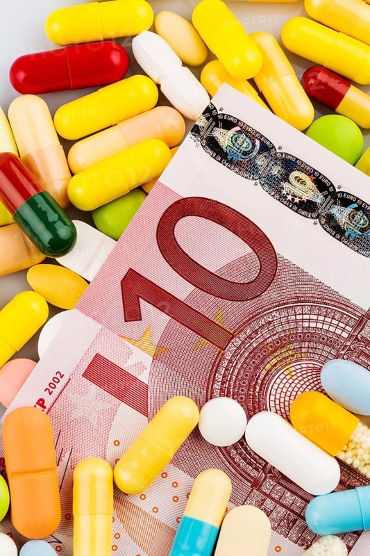 Euro banknotes and tablets, symbolic photo of medication and health insurance costs, Austria