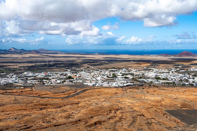View of town, white houses of Teguise with church tower in dry volcanic landscape, Lanzarote, Canary Islands, Spain