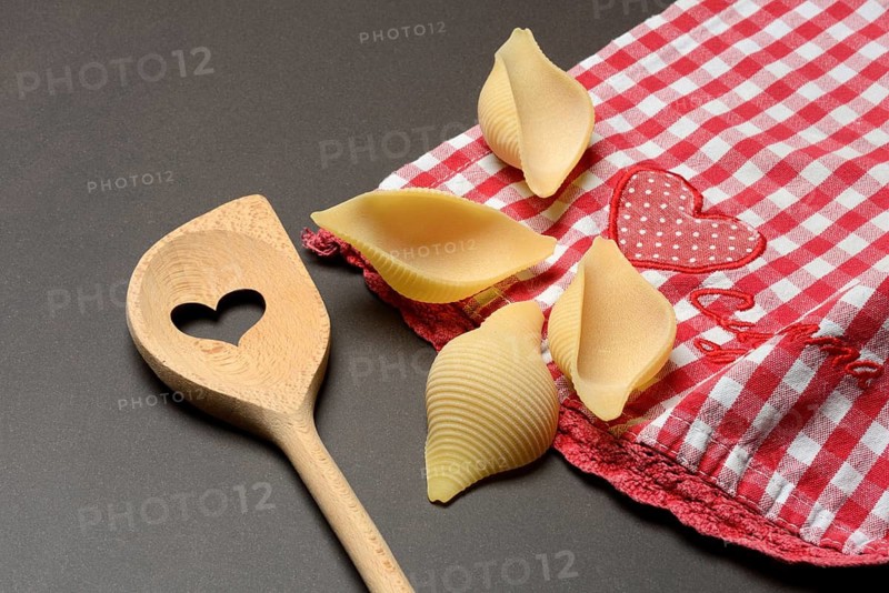 Conchiglione with wooden spoon, Italian pasta variety against a dark background, Italy