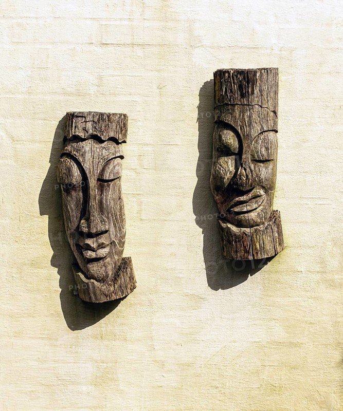Old African wooden mask sculptures over a white wall