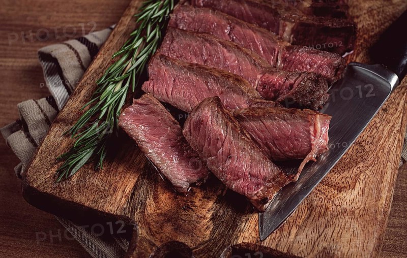 Fried steak, beef steak, rib eye steak, sliced steak, on a chopping board, top view, no people