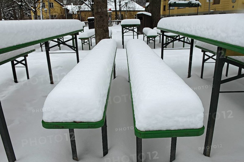Winter in the English Garden, snow-covered beer garden tables and benches, Munich, Bavaria, Germany