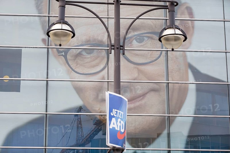 An election poster of the far-right AfD party (now AfD) hangs in front of a portrait of Friedrich Merz, the party chairman of the CDU, in front of the Konrad Adenauer House. Just after the 80th anniversary of the liberation of the Auschwitz concentration camp, the CDU chairman tabled a motion in favour of a tougher migration policy, which was only won thanks to the votes of the AfD. Berlin, 01.02.2025