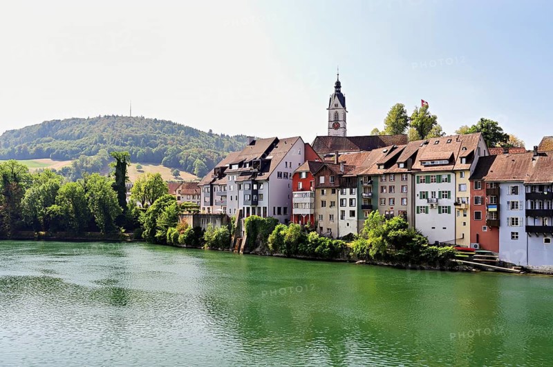 Cityscape with St. Johann Roman Catholic Church and historic houses on the banks of the Rhine River, Laufenburg, Canton of Aargau, Switzerland