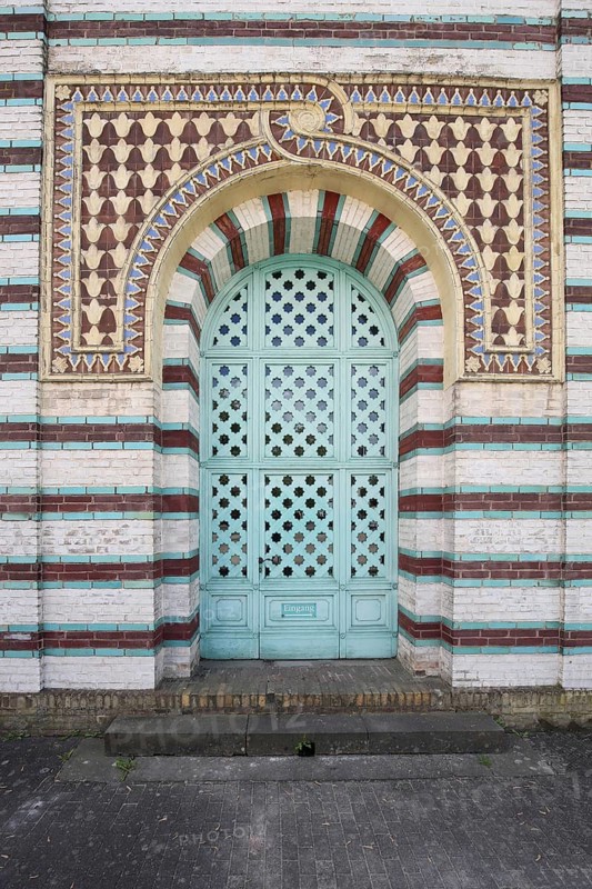 Metal door with decorations, patterns and bars, brick building with red, turquoise and white stripes, steam engine house, mosque, pump house, Potsdam, Havelland, Brandenburg, Germany