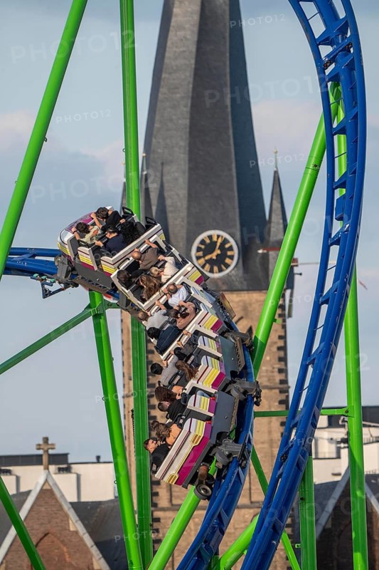 Rhine fair in the Rheinwiesen in Düsseldorf-Oberkassel, Alpina Bahn rollercoaster, in the back church tower of the Basilica of St. Lambert on the banks of the Old Town, North Rhine-Westphalia, Germany