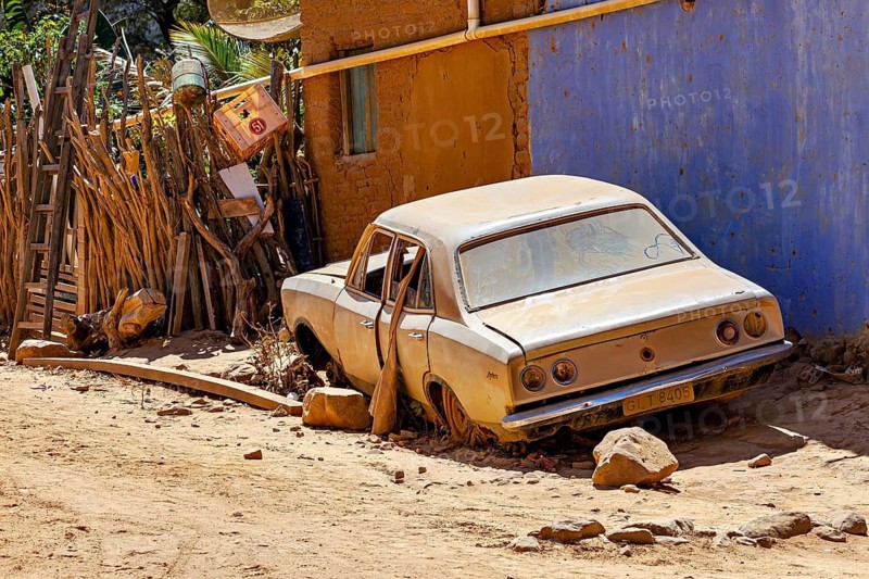 Abandoned old car in dusty desert environment with dilapidated fence and sunny light, old junk car in Campo Formoso in Caatinga in Bahia in Brazil