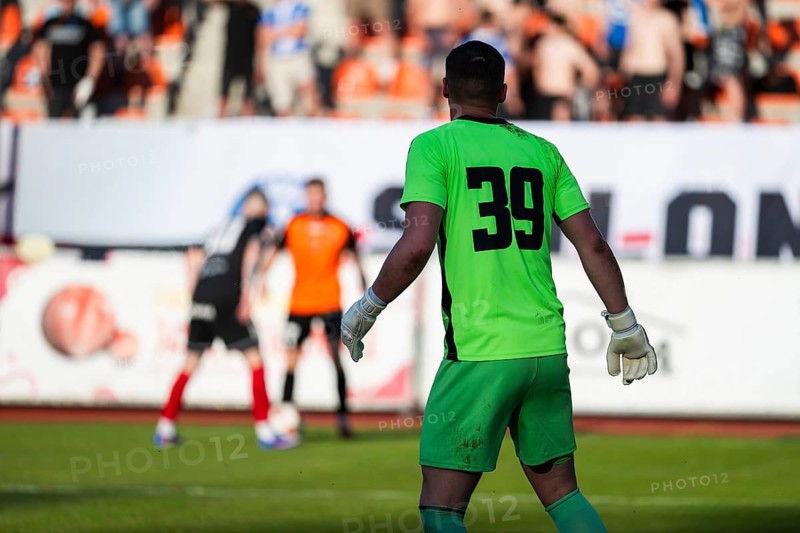 Goalkeeper in bright green uniform number 39 watching play during soccer match, real action moment in stadium in Glogow, Poland