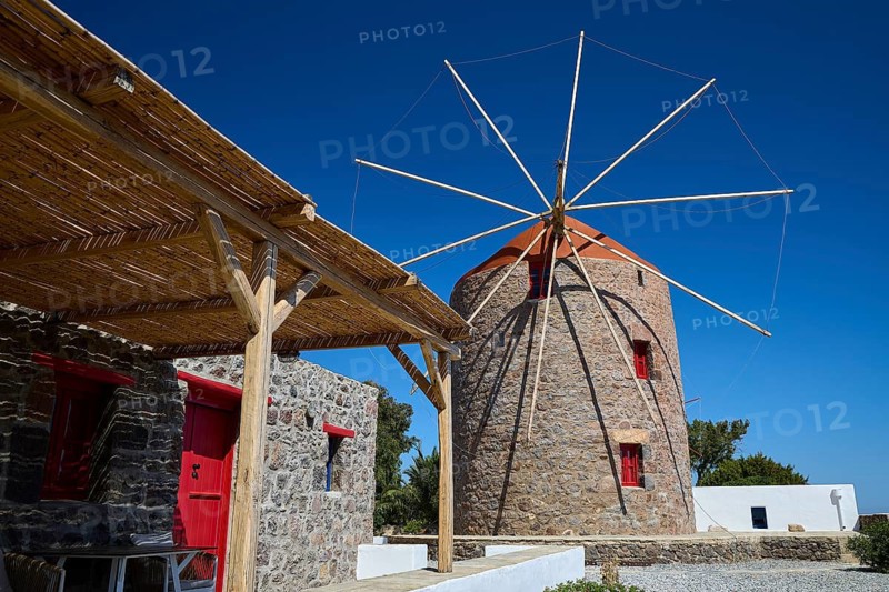 Stone windmill with red roof and wooden canopy under clear sky, Trypiti, Tripiti, village, Milos, island, Cyclades, Greek Islands, Greece