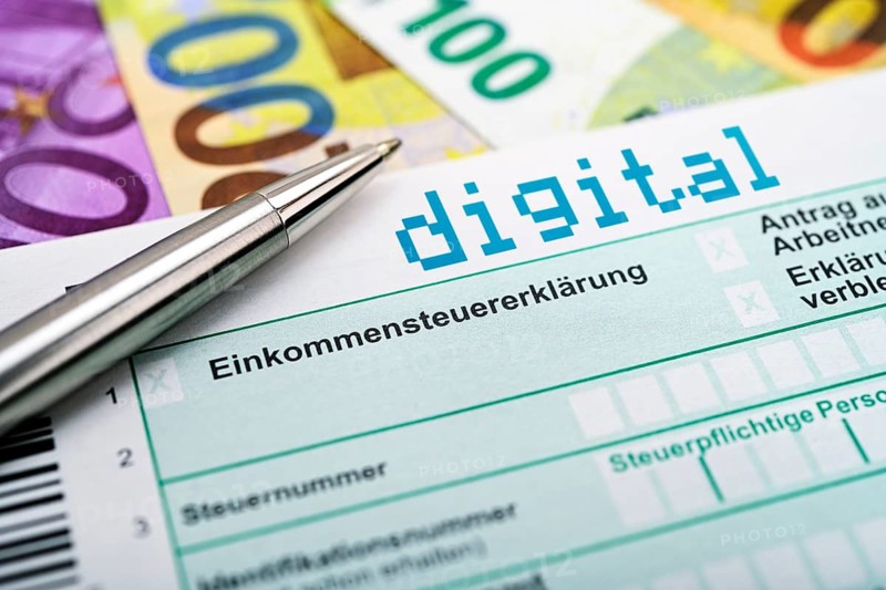 Income tax return with digital inscription and bank notes, digital income tax return, photo montage +++ editorial use only