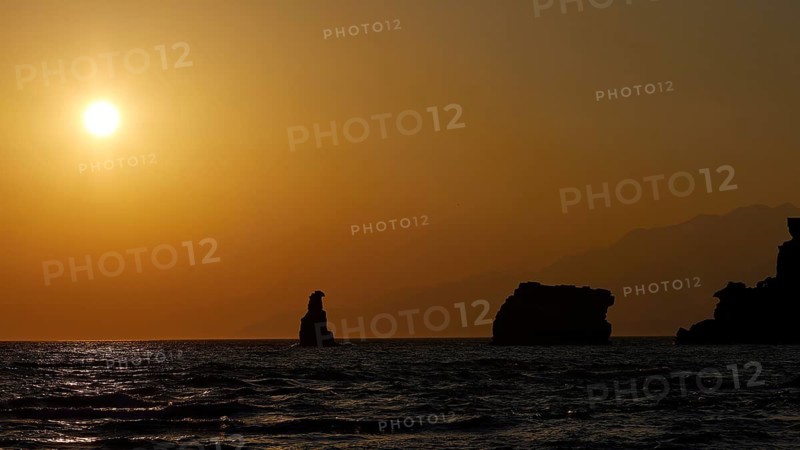Sunset at sea with silhouette-like rocks under a warm orange sky, sunset, South of the Amari Basin, Central Crete, Triopetra, rocks in the sea, Crete, Greek Islands, Greece
