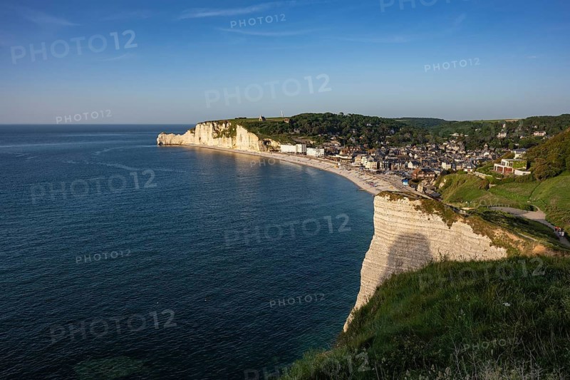 View from the Falaise d'Aval viewpoint down to the pebble beach of the seaside resort of Étretat with the steep cliffs of the Falaise d'Amont rock formation and the Notre Dame de la Garde chapel above it, Alabaster Coast, La Côte d'Albâtre, chalk cliffs, English Channel, Seine-Maritime, Normandy, France