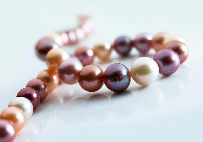 String of coloured pearls against a white background, studio shot