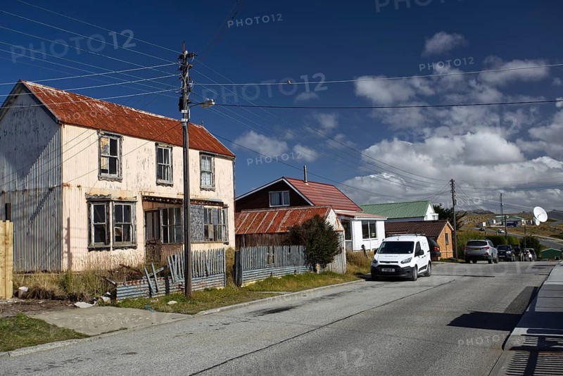 Small village street with old and new houses, cars parked, under a clear blue sky, Stanley, East Falkland, Falkland Islands (UK), British Overseas Territory