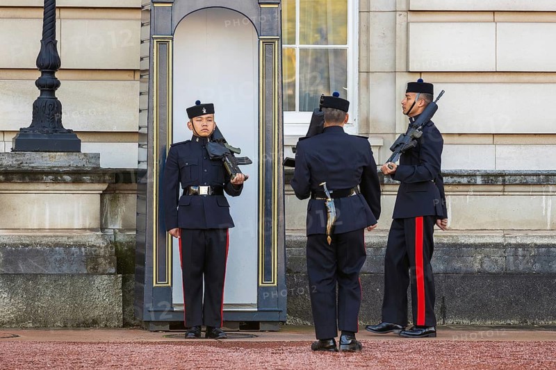 Queen's Gurkha Signals soldiers stand beside a sentry box during the changing of the guard at Buckingham Palace, London, England, United Kingdom