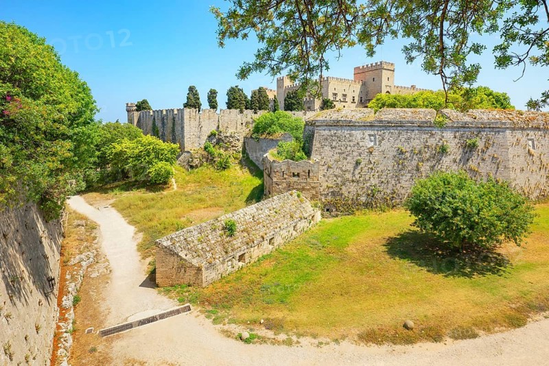 View of Rhodes city medieval defensive walls and Palace of the Grand Master of the Knights of Rhodes in the distance, Rhodes City, Rhodes Island, Dodecanese Islands, Greece