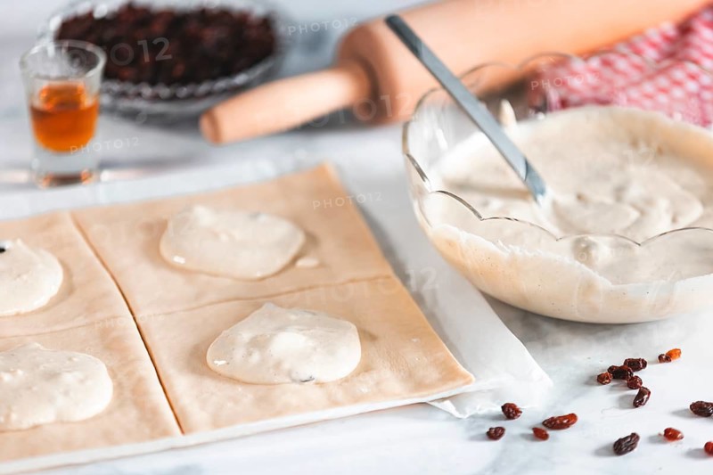 Dough divided into squares is filled with curd cream