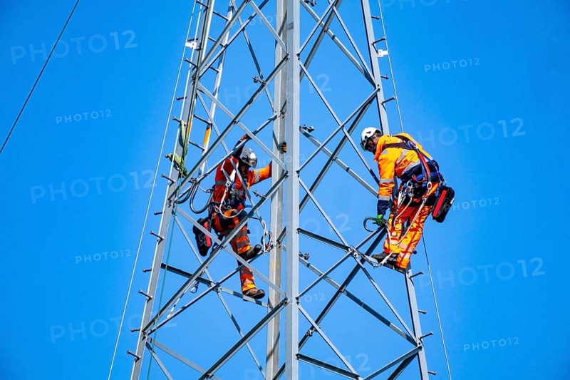Fitters erecting a steel lattice tower as part of a 380 KV extra-high-voltage line between Wesel and Düsseldorf to increase transmission capacity in the Rhineland, the old 220 KV line is being dismantled, Neukirchen-Vluyn, North Rhine-Westphalia, Germany