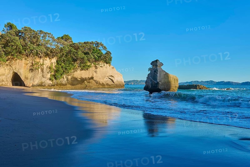 Rocks on a quiet beach under a blue sky, Cathedral Cove, Coromandel, Canterbury, North Island, New Zealand