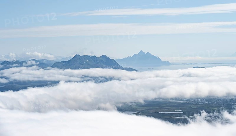 Mountain peaks above the clouds, mountain landscape and sea, view from the summit of Stornappstinden, Lofoten, Nordland, Norway