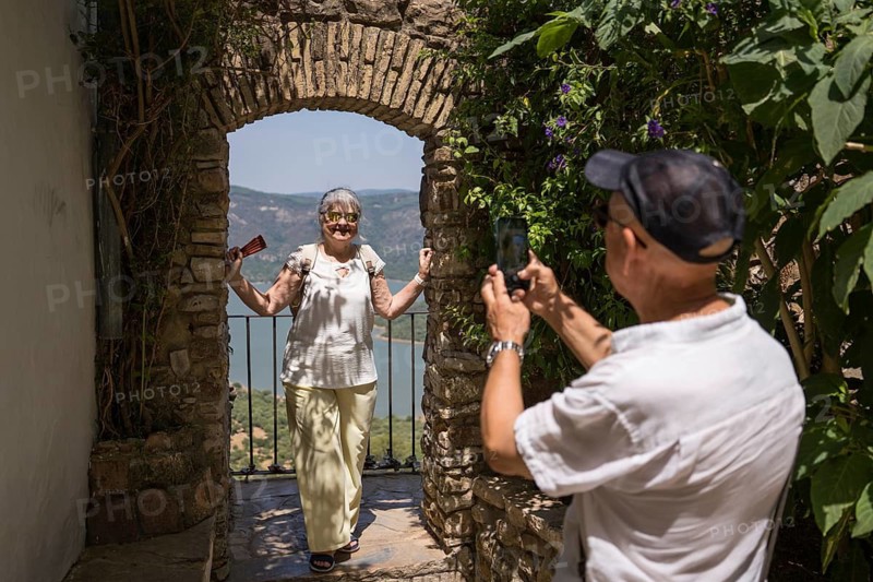 A senior couple enjoys a leisurely walk through a historic white village during their vacation in southern Spain, capturing the serene and picturesque views around them