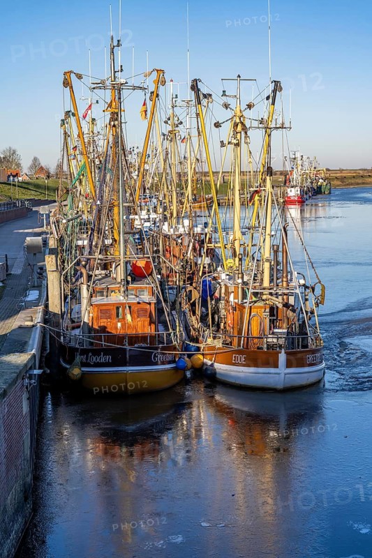 The fishing village of Greetsiel, historic fishing harbour, with the largest shrimp cutter fleet in East Frisia, historic houses, winter, partly frozen, in Lower Saxony, Germany