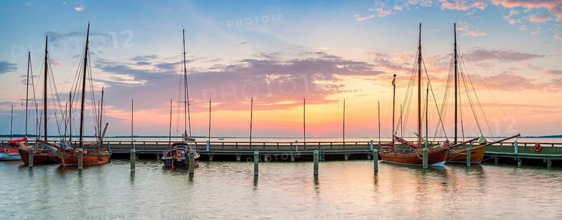 Sailboats and Zeesenboats in the harbour of Dierhagen on the Saaler Bodden at sunrise, Fischland-Darß-Zingst, Mecklenburg-Vorpommern, Germany