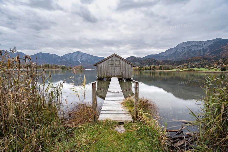 Boathouse in the lake, Lake Kochel in autumn with reflection, Upper Bavaria, Bavaria, Germany