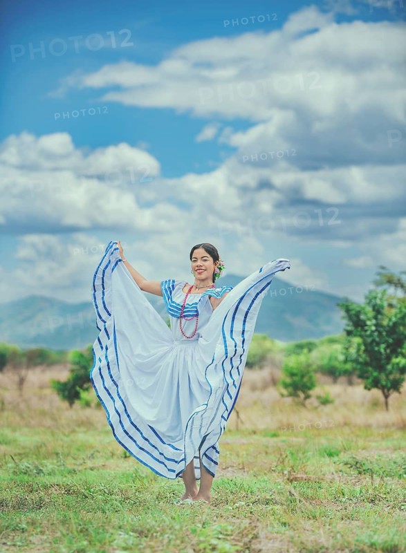 Woman wearing traditional Nicaraguan folk costume in a field. Smiling girl in national folk costume in the field