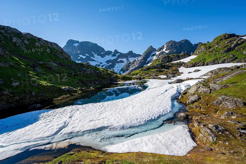 Lake with snow remains, Landscape at the mountain hut Trollfjord Hytta, Rocky mountain peaks with snow remains, Mountain landscape at Trollfjord, Lofoten and Vesterålen, Nordland, Norway