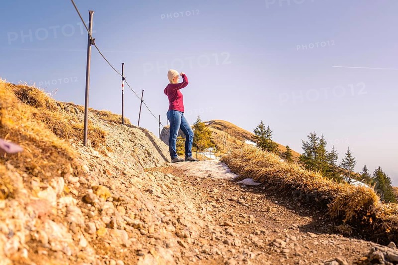 Woman standing on a rocky path with a wide view over the mountain landscape, Hochgrat Mountains, Allgäu Alps, Oberreute, Germany