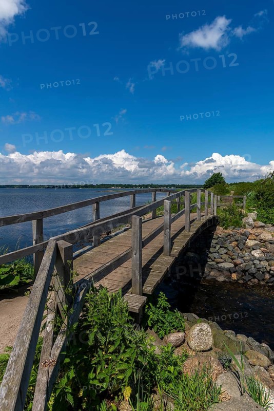 Small Noor in the nature reserve Holnis peninsula, NSG, German, Danish border area, wooden bridge over the connection to the fjord, blue sky, white clouds, Glücksburg, Schleswig-Holstein, Germany